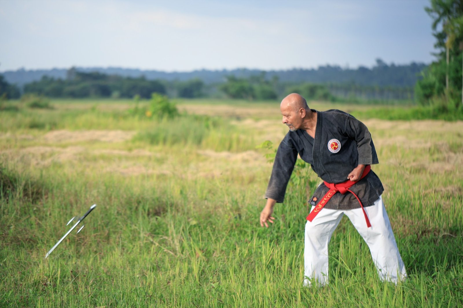 hanshi ravindran k.p demonstrating a dynamic and skilled throwing technique with a traditional sai weapon. (large)