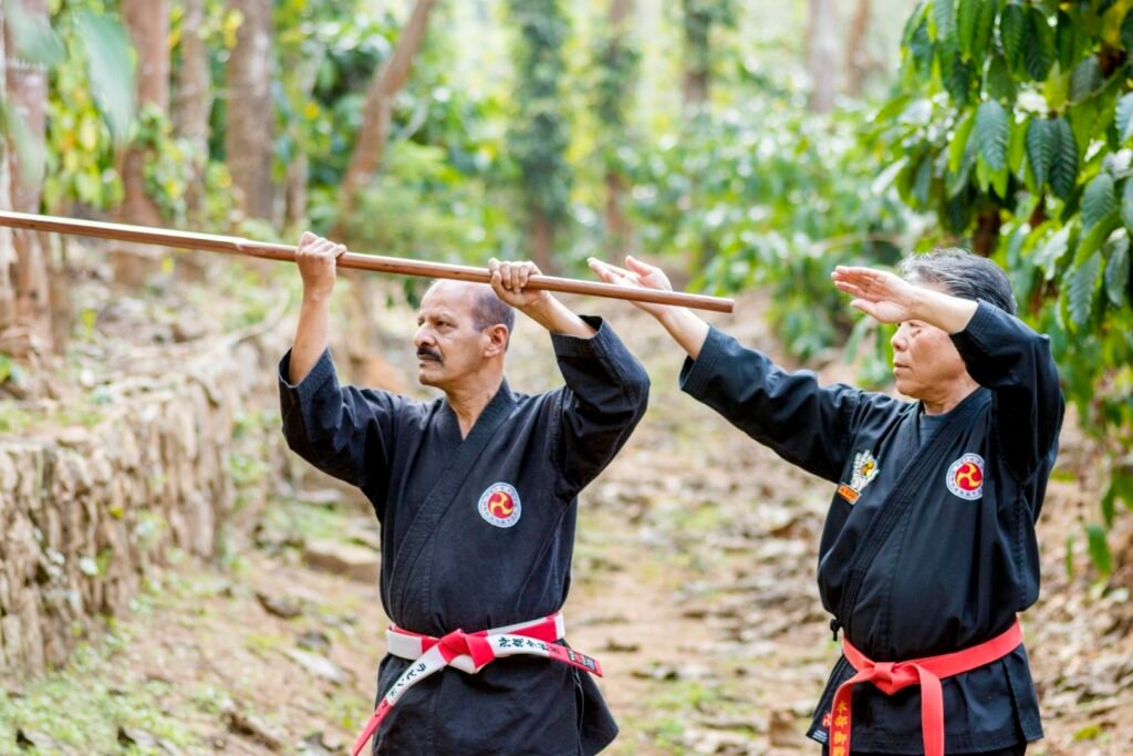 hanshi tetsuo takamiyagi providing precise kobudo technique correction to hanshi ravindran k.p during training. (large)