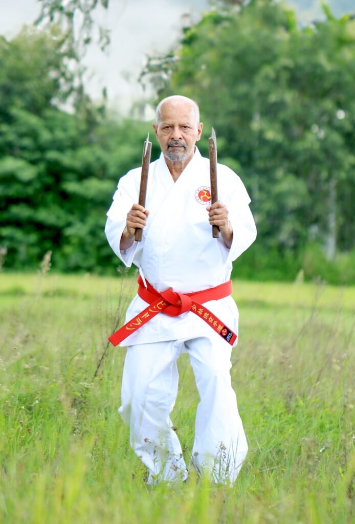 hanshi ravindran k.p demonstrating dynamic and skilled techniques with traditional okinawan kama weapons. (2)